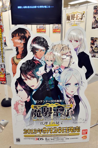 「バンダイナムコゲームス」ブースに設置された、作画担当の雪広うたこさんとキャストさんのサイン入りポップ