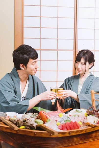 海の幸を肴に乾杯するカップル