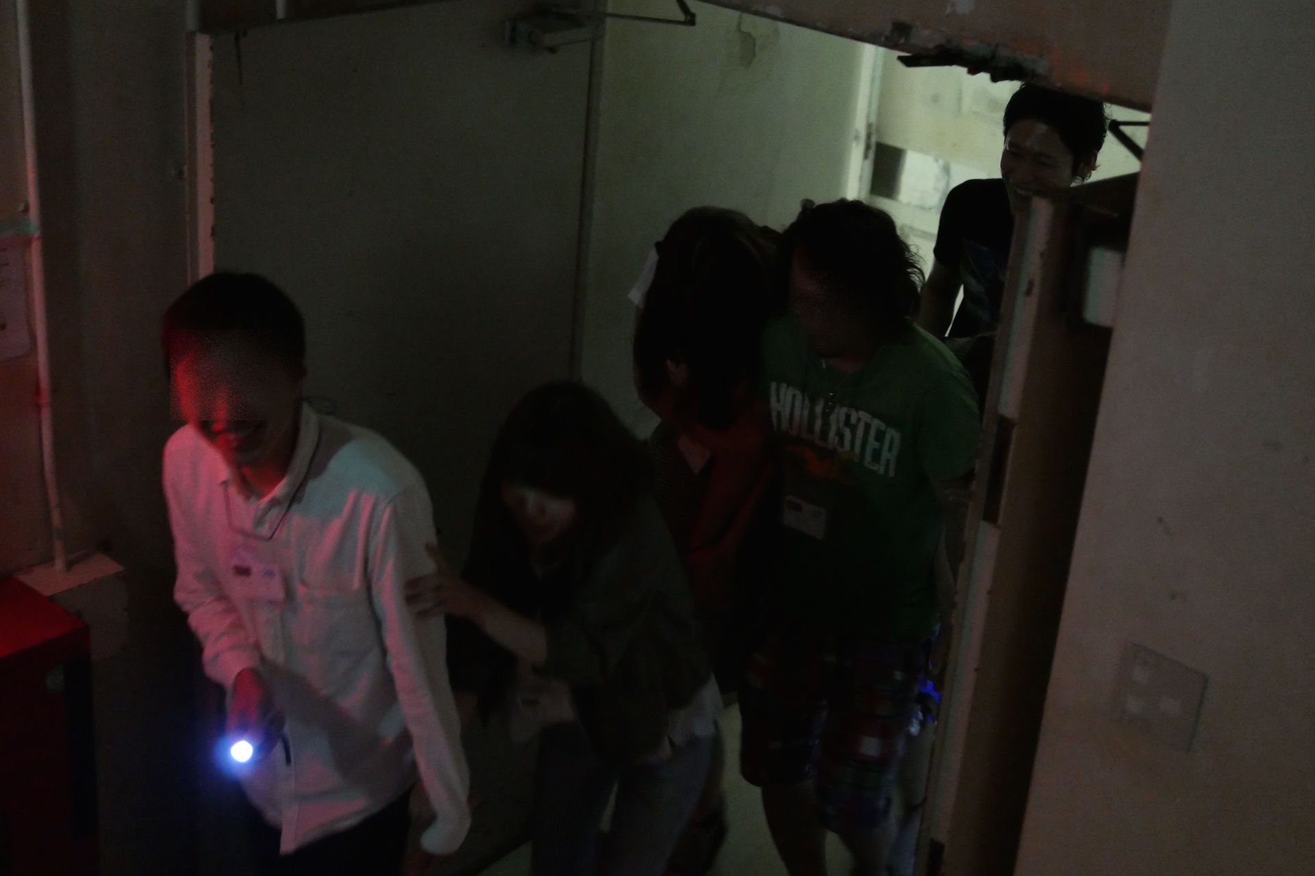 ※写真は過去の開催風景。真っ暗な病院をグループで進む