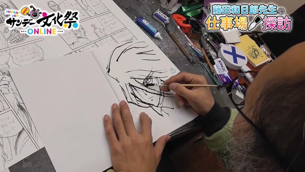 割りばしにインクを付けて作画する藤田さん／画像は動画のキャプチャ