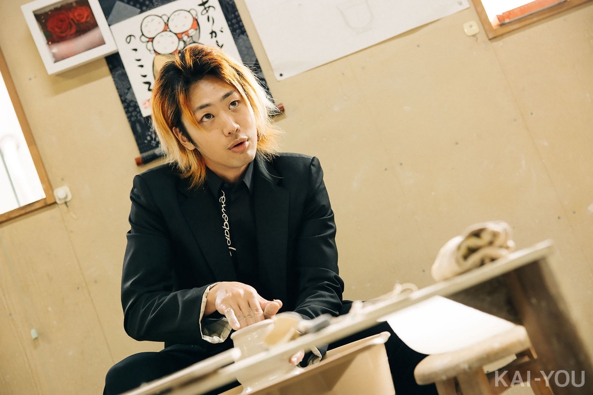 真剣な表情でろくろを回しながらインタビューに答えるてつやさん